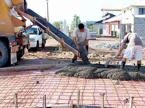 Concrete truck chute pouring wet cement Mix into metal bucket